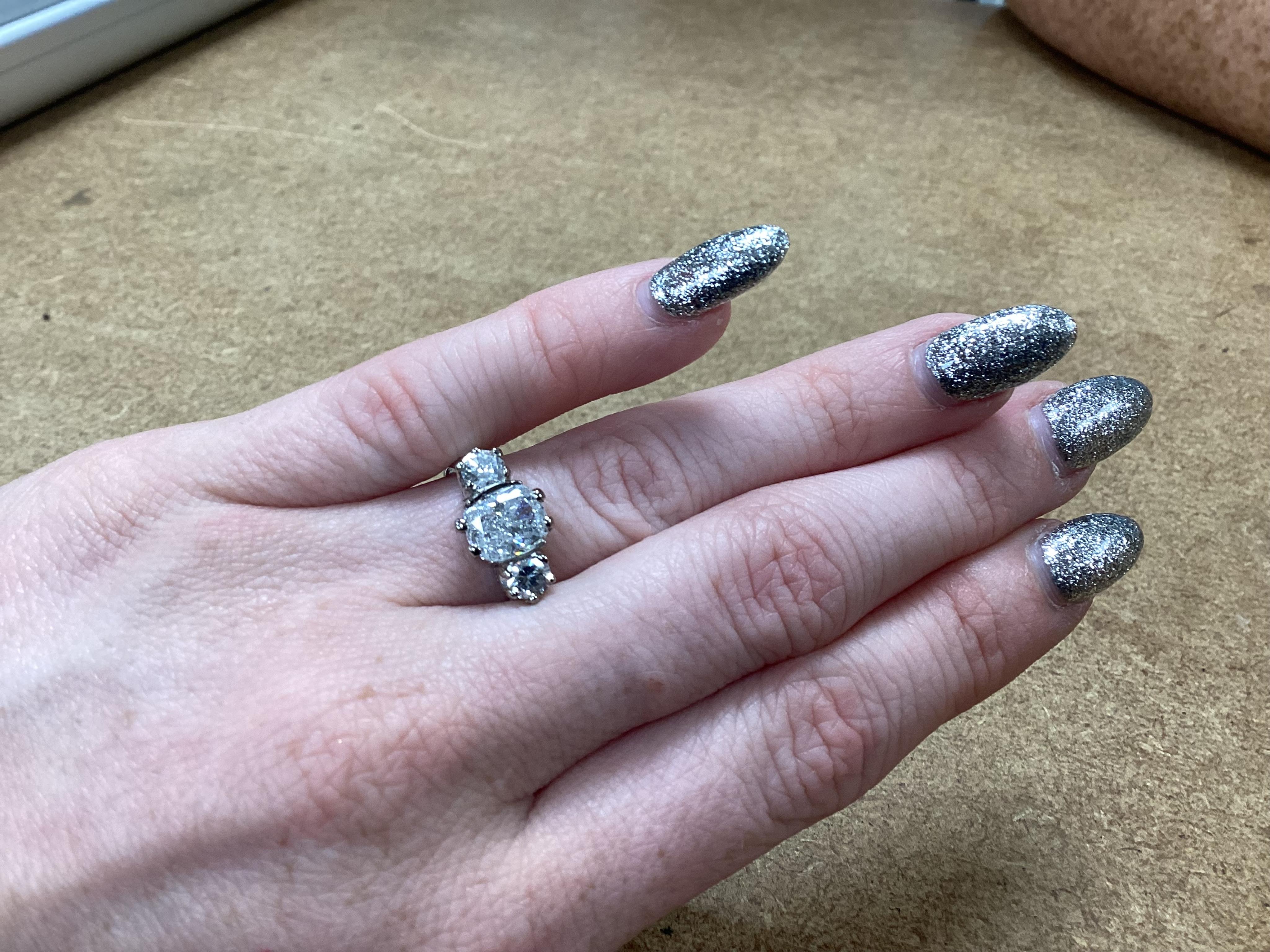 A diamond ring, set with a cushion-shaped diamond weighing 1.50 carats, between shoulders set with brilliant-cut diamonds totalling approximately 0.40 carats, size K, gross weight approximately 4 grams, Condition: centra